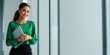 © Yevheniiya - Attractive young professional woman in green blouse holding a laptop, smiling confidently