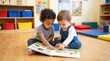 © AspctStyle - Two diverse toddlers reading a picture book in a bright classroom, early childhood education and friendship concept, preschool children learning.