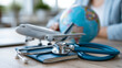 © Nataliya - Close-up of a stethoscope, passport, airplane and globe arranged together, healthcare and travel insurance concept, medical travel photography, global health insurance