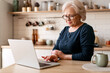 © Maria Vitkovska - Senior woman experiencing wrist pain working on laptop at home