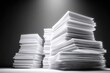 © nameera_juwairiya - Stacks of paper documents in dramatic studio lighting