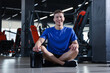 © New Africa - Happy young man with jar of protein powder in gym