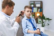 © New Africa - Hearing test. Doctor examining boy's ear with otoscope in clinic