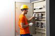 © New Africa - Electrician with screwdriver checking electrical meter indoors