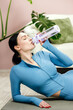 © wedmoments.stock - Young sporty woman refreshing with bottled water after training. Concept healthy body, fitness motivation and wellness lifestyle.