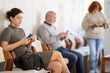 © JackF - Young girl sitting in clinic waiting area scrolling mobile phone while waiting for medical appointment