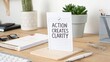© Finasulizi - Inspirational Workspace Quote on Action and Clarity in Minimalist Office Environment with Plants and Stationery