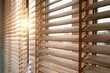 © Maraku - Wooden window blinds filtering warm sunlight in a cozy interior setting with golden hour glow for home decor and interior design marketing