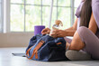 © Pixel-Shot - Sporty young woman with bottle of water and bag sitting on yoga mat in gym, closeup