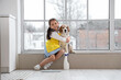 © Pixel-Shot - Cute little Asian girl hugging Beagle dog on windowsill at home