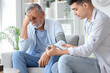 © Pixel-Shot - Worried senior man having blood pressure checked by caregiver at home, elderly patient with hypertension and headache during home healthcare visit