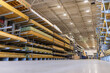 © Andrei Liashchou - Low-angle view of organized stacks of lumber and pressure-treated wood boards stored on heavy-duty cantilever racks inside a large home improvement warehouse store, USA