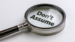 © Bilal - Magnifying glass revealing the cautionary phrase 'Don't Assume' on a pristine white.