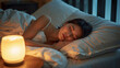 © bephoto - 心を落ち着かせる灯りの中で眠る日本人女性の上質な快眠イメージ写真