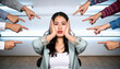 © lloyd - A person sits, head down, hands over ears, surrounded by accusing fingers pointing