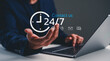 © Rawat - Person in suit gestures towards laptop with 24/7 contact icons, symbolizing constant availability and customer support