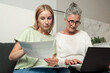 © brizmaker - Young adult daughter helps senior mother with important documents