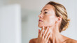 © dinatychynska - Young woman massages chin and jawline to lift double chin contour. Natural facial massage routine, skin tightening, anti-aging selfcare, morning glow, clean beauty ritual.