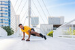 © oneinchpunch - Hispanic sportive man training outdoors in the city