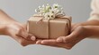 © Tata - Close-up of hands offering a beautifully wrapped gift with fresh blooms