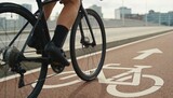Close view of a cyclist riding along a marked bike lane, wheels and road markings in sharp focus, background softly blurred with city buildings visible, soft diffused light, urban mobility concept