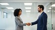 © MopoWe - Diverse male and female professionals shaking hands in a bright contemporary workspace. Clean minimalist background with glass partitions and soft bokeh. Ideal for recruitment marketing.