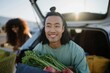 © Andrii Zastrozhnov - Young man carrying grocery bag smiling at open car trunk lot