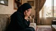 © Анастасия Макевич - Emotional Muslim woman crying at home while covering face expressing grief sadness and personal struggle