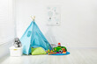 © New Africa - Wigwam, toys and pillows near white wall in child's room, space for text