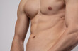 © skeronov - A young man with an elastic torso and prominent muscles is dressed in tight jeans after sports. Concept: body parts, men's health. The flexible and agile body of a dancer or athlete