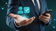 © Evelyn - Businessman holding smartphone with hand presenting user profile icon and checkmark, identity verification, account approval, secure login, authentication process, customer