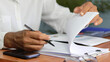 © Siwaporn - Medical professional analyzing healthcare data and charts while working on laptop and documenting results at office desk. Concept of health insurance review, medical assessment, data-driven decision