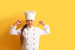 © Pixel-Shot - Little chef showing dislike on yellow background
