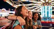 © NANIN - Three teenage friends laughing while riding an amusement park carousel at night