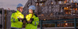 © BESTIMAGE - Two petroleum engineers team male and female hold tablet discussing and monitoring data for maintenance during night shift at oil refinery plant engineering teamwork industrial energy operation.