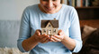 © Lily - Smiling woman holding small house model in hands, concept of home ownership and real estate investment, happy homeowner with miniature residential building