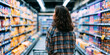 © Ekaterina Pokrovsky - Young woman choosing bottled drinks in a supermarket aisle, representing grocery shopping, consumer choice, retail products and everyday food purchasing decisions