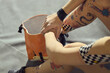 © TrueFrame Collective - Young adult woman gripping forearm and preparing for climbing beside chalk bag, showing focus and strength
