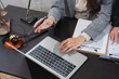 © Kritdanai - Legal Consultation: A close-up shot captures a legal professional meticulously reviewing a contract on a laptop, with a gavel and scales of justice visible on the desk.