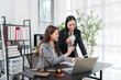© Kritdanai - Legal Collaboration: Two women, likely lawyers or paralegals, in a professional setting, work together diligently reviewing documents at a desk equipped with a laptop and legal scale.
