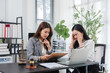 © Kritdanai - Legal Consultation and Distress: Two professional women in a legal setting, one offering consultation while the other shows clear signs of distress and anxiety.