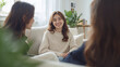 © bephoto - 窓辺の部屋で日本人女性が友人との会話に笑顔を見せる写真