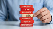 © Lukman - Professional hand carefully extracting 'Risk' block from a strategic business process tower, symbolizing crucial risk management, assessment, and mitigation in corporate planning