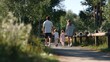 © ประหยัด พลพวก - Family Stroll in Nature: A heartwarming scene of a family, parents and two young children, walking hand-in-hand on a sun-dappled path through a lush, green park, enjoying a peaceful outdoor excursion.