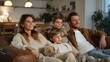 © ประหยัด พลพวก - Cozy Family Night In: A warm and inviting scene of a family – parents and their two young sons – relaxing on a comfortable sofa, engrossed in watching something together.