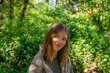 © Viks - Young Woman with Warm Smile in Lush Green Outdoor Setting, Natural Light