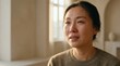 © Desy - Close-up portrait of a distressed East Asian woman crying with tears streaming down her face, illuminated by soft natural light from a window indoors.