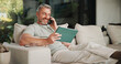 © peopleimages.com - Phone call, smile and tablet for remote work with man on sofa in home living room as freelancer. App, conversation and research with mature person in apartment for report or review as happy employee