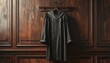 © Ardijojo - Dark formal robe with a collar and white trim, hanging on a wooden wall. The dark robe is suspended in a traditional setting and displays a clean and refined aesthetic with elegance.