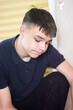 © dizfoto1973 - Portrait of a Pensive Teenage Boy Looking Down, Sad Young Man in Dark Polo Shirt Showing Contemplation and Emotion